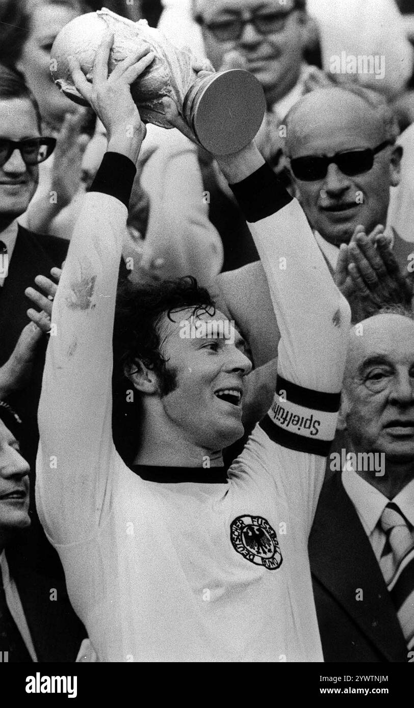 Photo datée du 9-07-1974 du capitaine Franz Beckenbauer détient le trophée de la Coupe du monde après avoir battu Holland 2-1 en finale à Munich, Allemagne. Le grand allemand Beckenbauer, un autre des trois hommes à avoir remporté la Coupe du monde en tant que joueur et entraîneur, a été surnommé «Der Kaiser» (l'empereur) pour son style de commandement sur le terrain. Il meurt peu après Zagallo, âgé de 78 ans. Date d'émission : jeudi 12 décembre 2024. Banque D'Images
