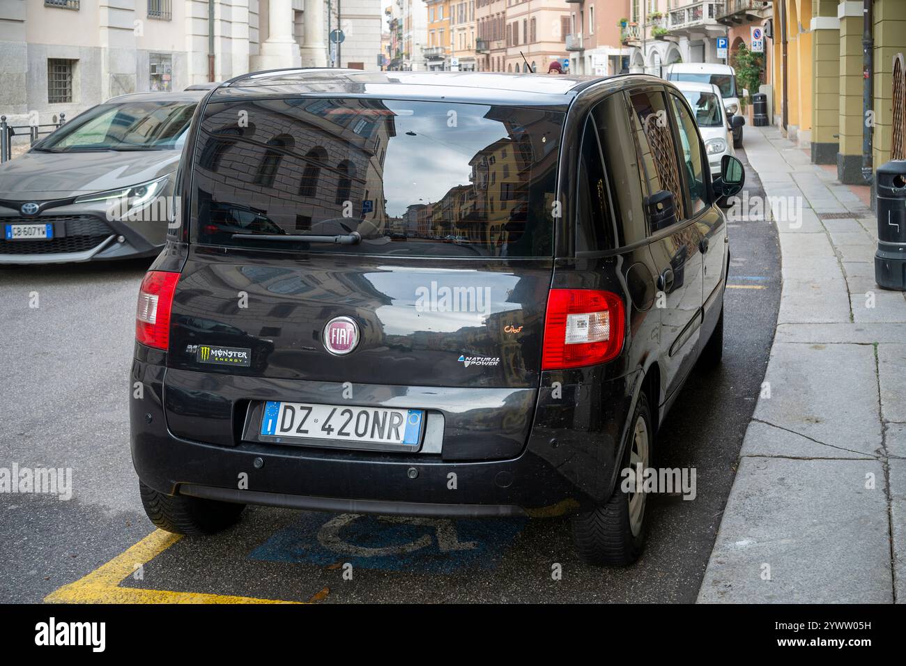 Cremona, Italie - 27 novembre 2024 voiture à méthane noire Fiat multipla à puissance naturelle garée reflétant les bâtiments environnants dans un cadre urbain en italie Banque D'Images