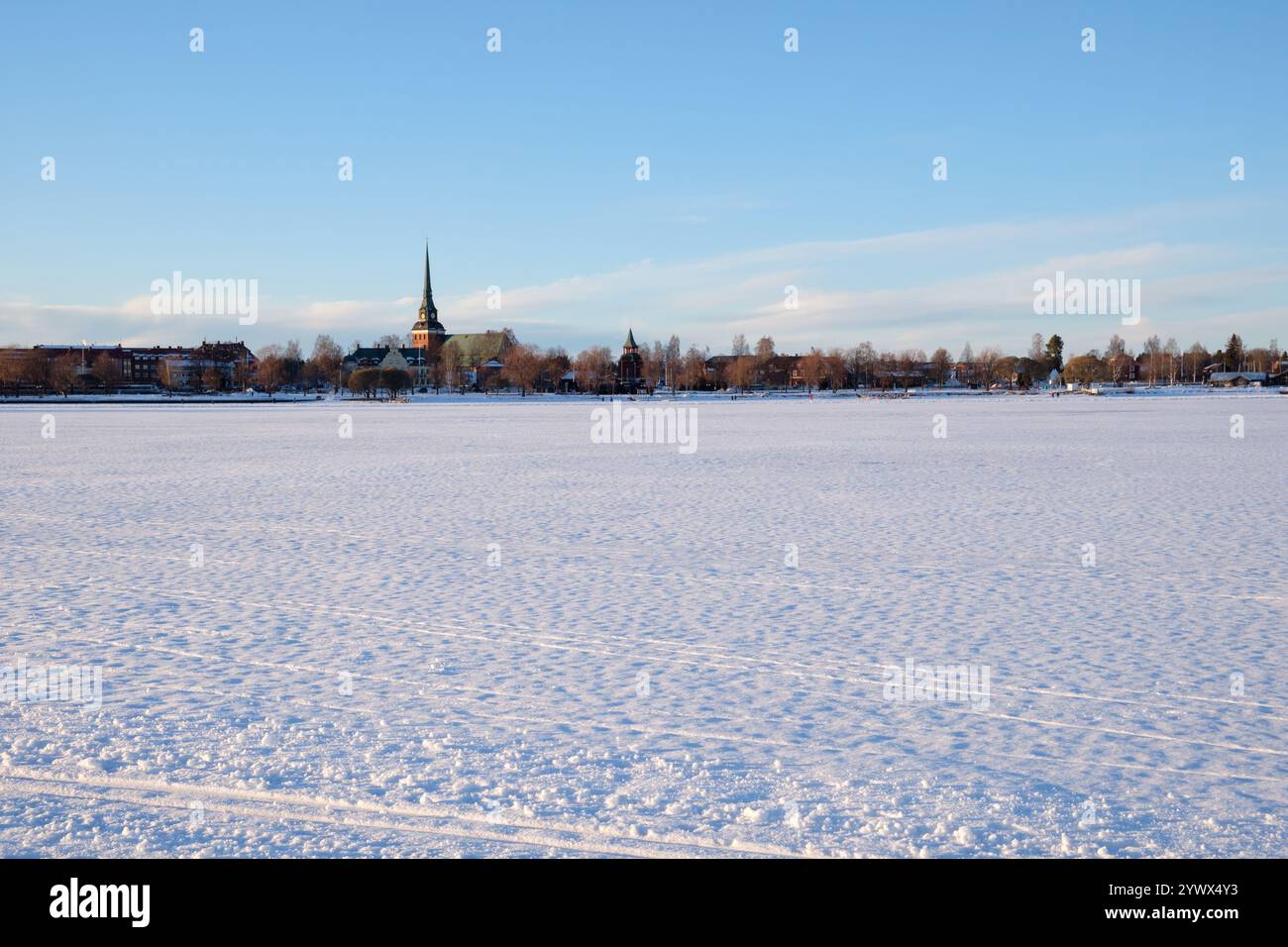 Un paysage hivernal serein capturé à Mora, Dalarna, Suède. La scène met en valeur une vaste étendue enneigée avec une tour d'église visible au loin agai Banque D'Images