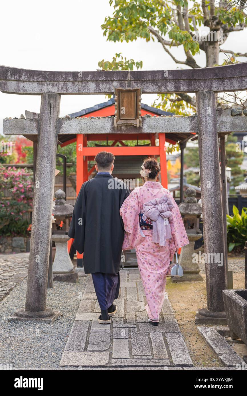 Un couple portant du kimono à Kyoto, au Japon. Les feuilles d'érable virent au rouge en automne. Fond traditionnel japonais. Banque D'Images