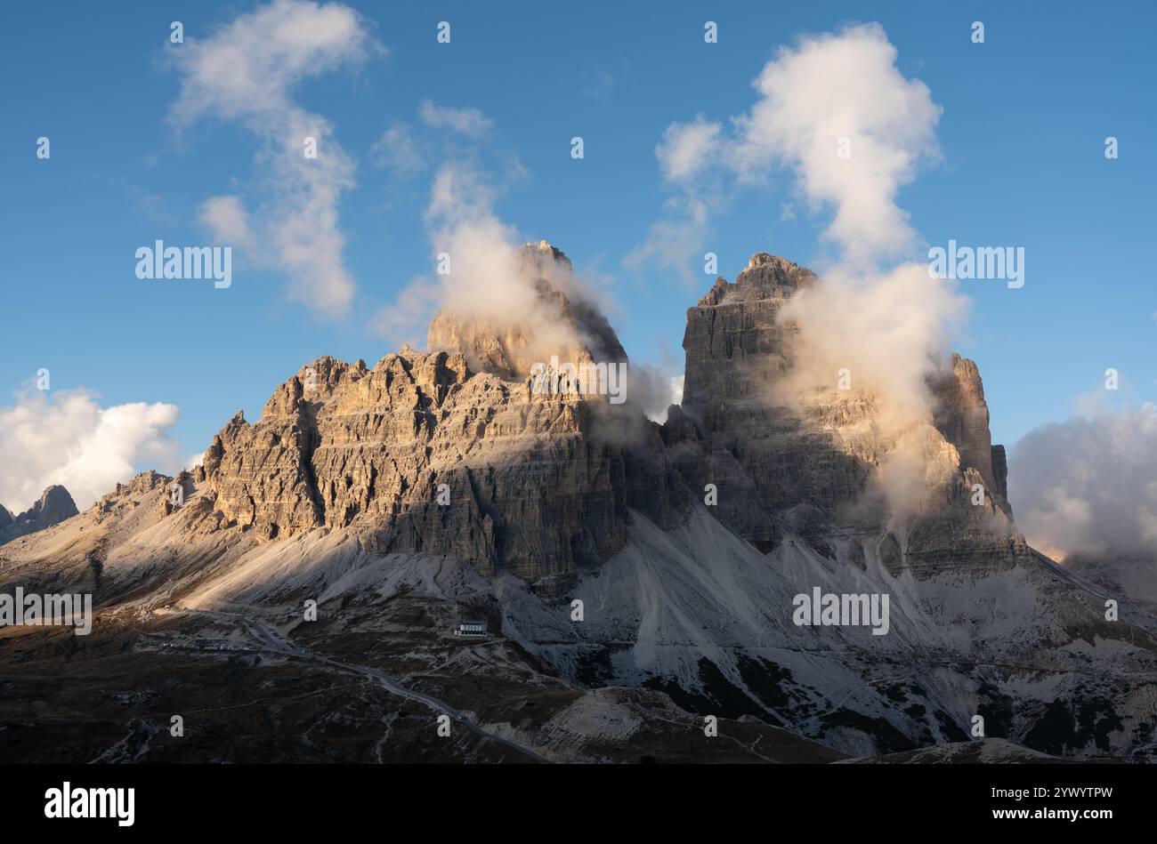 Vue imprenable sur Tre Cime di Lavaredo par une soirée d'automne ensoleillée avec un ciel bleu et des nuages clairsemés Banque D'Images