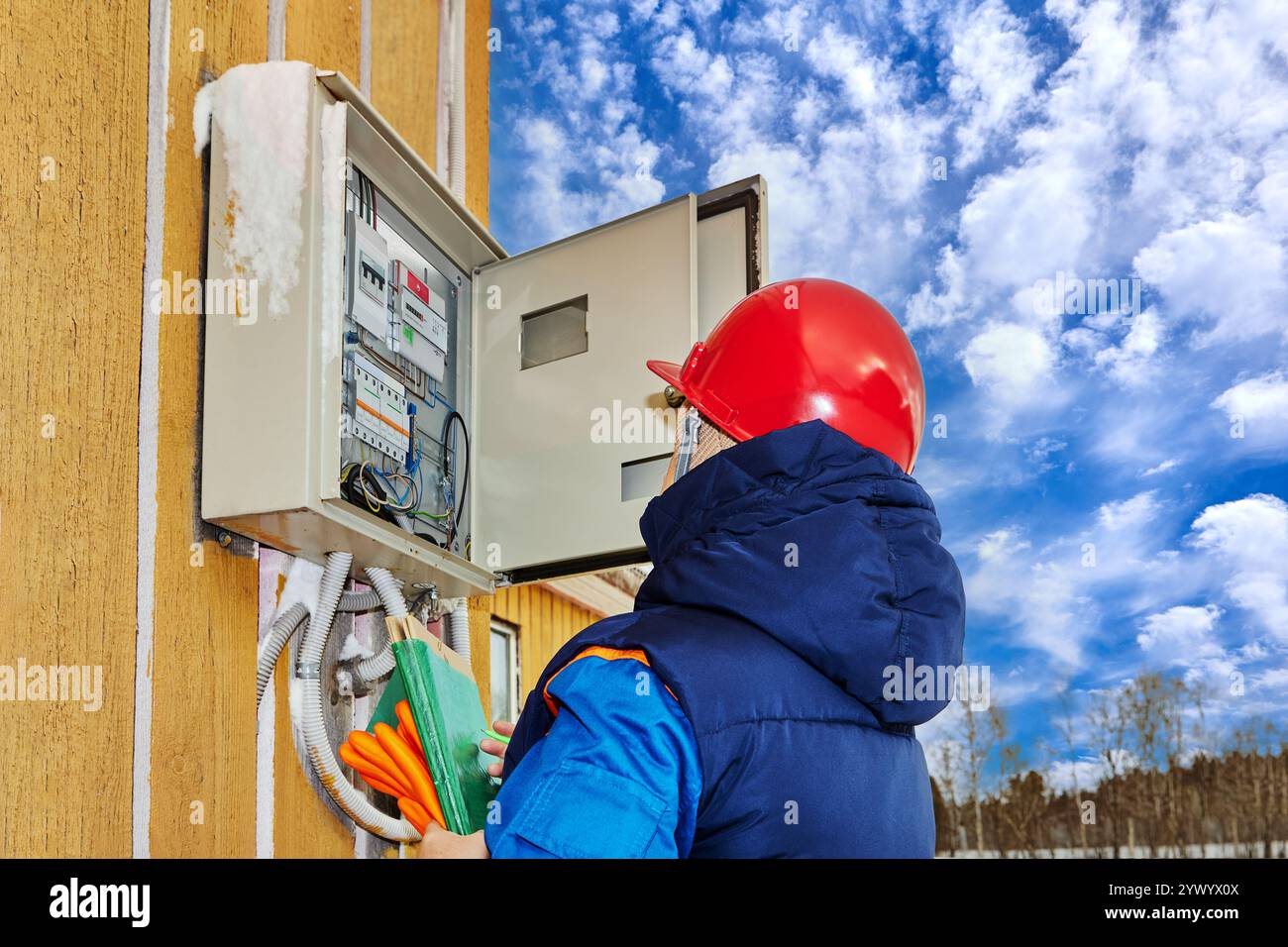 Un technicien d'une entreprise de services publics vérifie la fiabilité des fils de connexion dans un panneau électrique. Banque D'Images