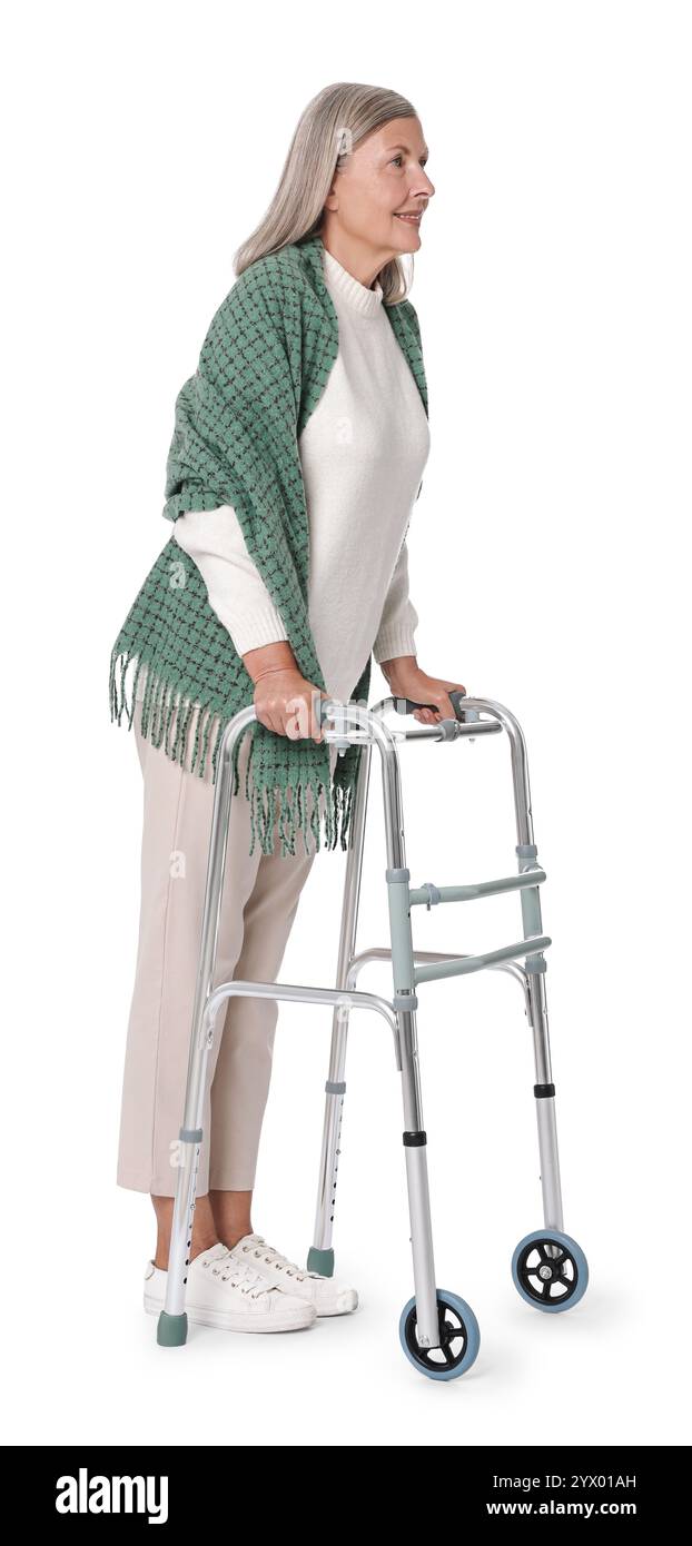 Femme senior utilisant le cadre de marche sur fond blanc Banque D'Images