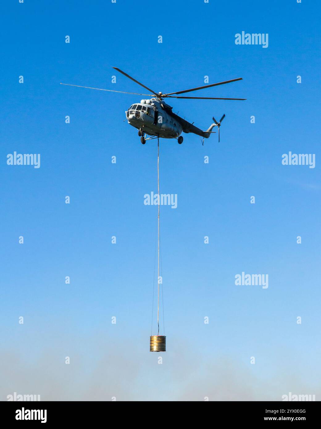 Dans l'action de l'hélicoptère transportant le réservoir d'eau. Tourné à partir du sol. Banque D'Images