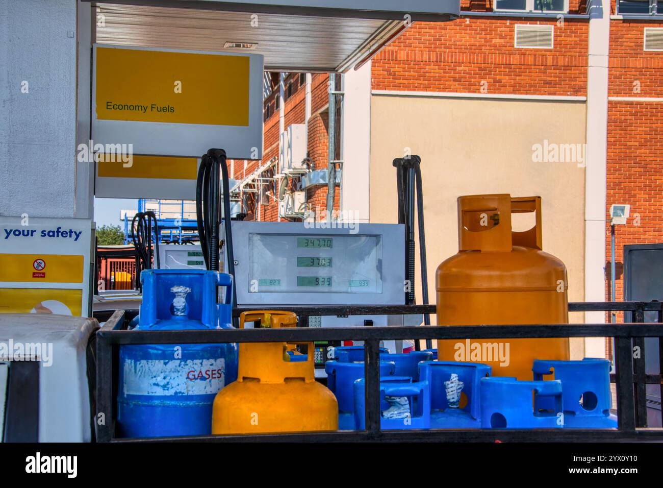 Bouteilles de gaz liquéfié, bouteille de gaz liquéfié, à une station-service pour le remplissage , à côté de la pompe à essence Banque D'Images