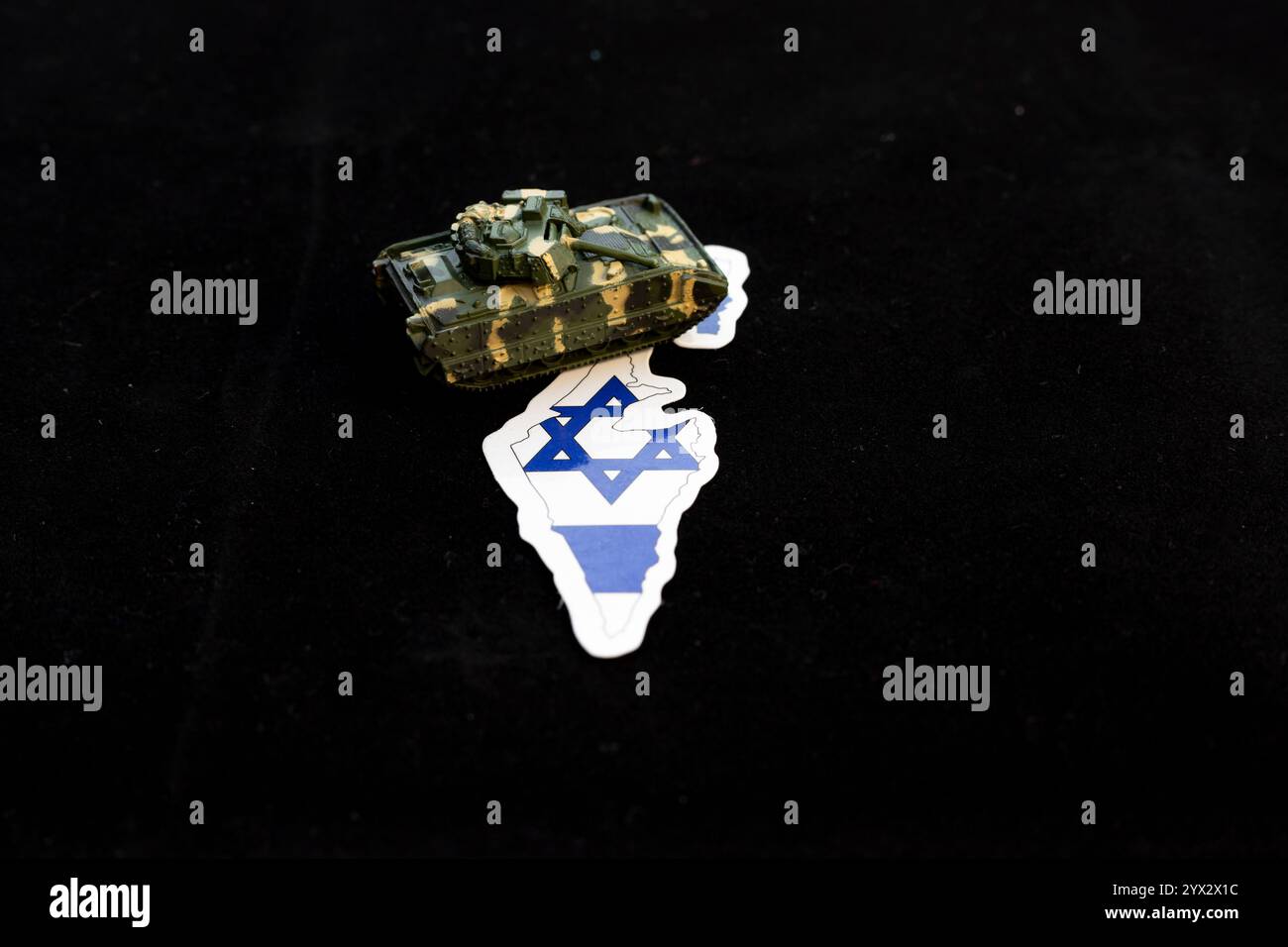 Réservoir de jouet sur le drapeau de la carte d'Israël. Symbolisme militaire et concept géopolitique. Banque D'Images