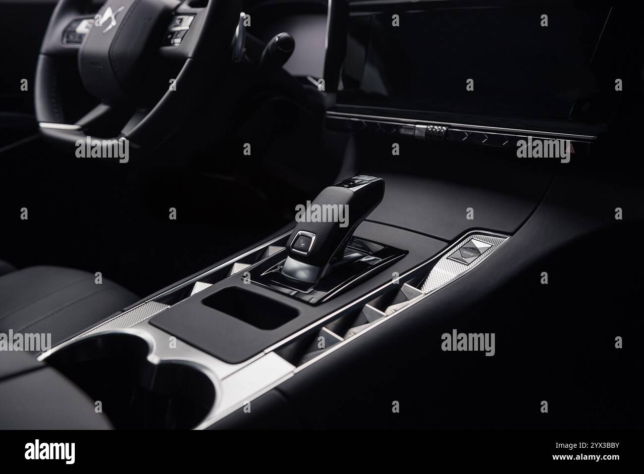 Sélecteur de vitesses automatique et console centrale dans DS7 Crossback. Intérieur de l'automobile dans les tons sombres, vue rapprochée du levier de vitesses, des boutons et des porte-gobelets Banque D'Images