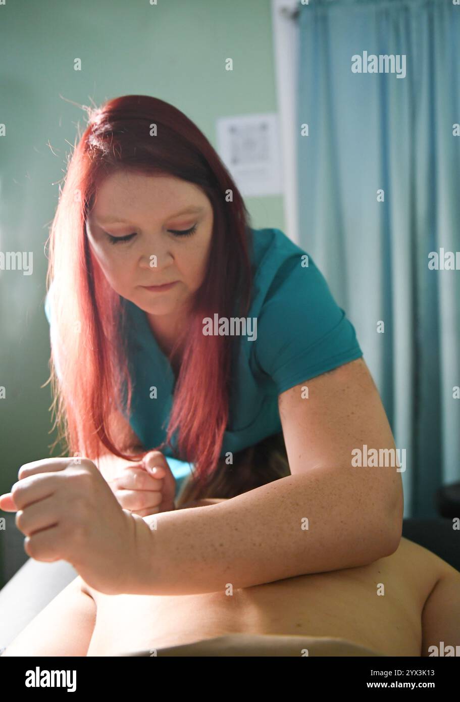 Massothérapeute utilisant une technique de l'avant-bras pour un ma de tissu profond Banque D'Images