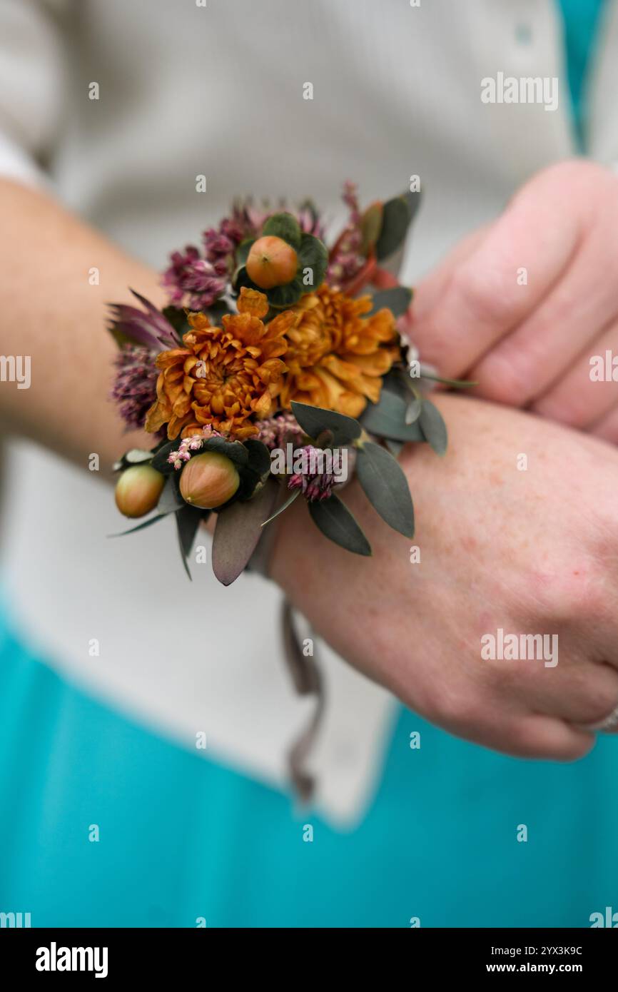 Corsage de poignet avec fleurs orange et rose sur fait de bras d'honneur Banque D'Images