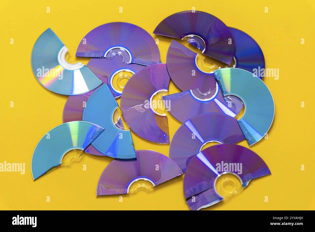 Vue de dessus des CD et DVD découpés sur fond jaune Banque D'Images
