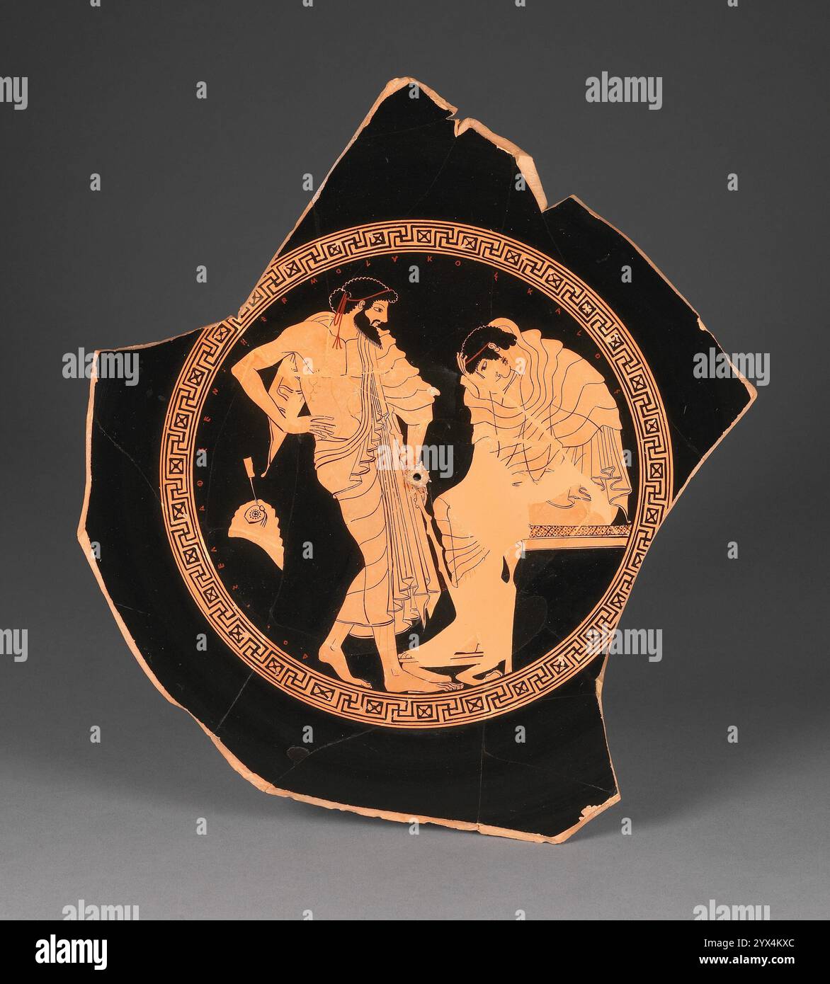 Grenier Red-figure Kylix, 490-470 av. J.-C. Coupe à vin fragmentaire avec Odysseus s'adressant à Achille. Informations supplémentaires : à l'intérieur de ce fragment d'une grande coupe athénienne à silhouette rouge, un jeune est assis avec découragement. Enveloppé dans sa cape, il repose sa tête baissée dans sa main. Un homme plus âgé et barbu se tient devant lui, appuyé sur un bâton. Bien qu'aucune figure ne soit nommée, la composition est proche d'autres scènes qui montrent la mission d'Odysseus dans la tente d'Achille, un épisode décrit dans Homère&#x2019;s Iliade. L'extérieur de la coupe montre une scène mythologique - Herakles en compétition avec les fils d'Eurytos ier Banque D'Images