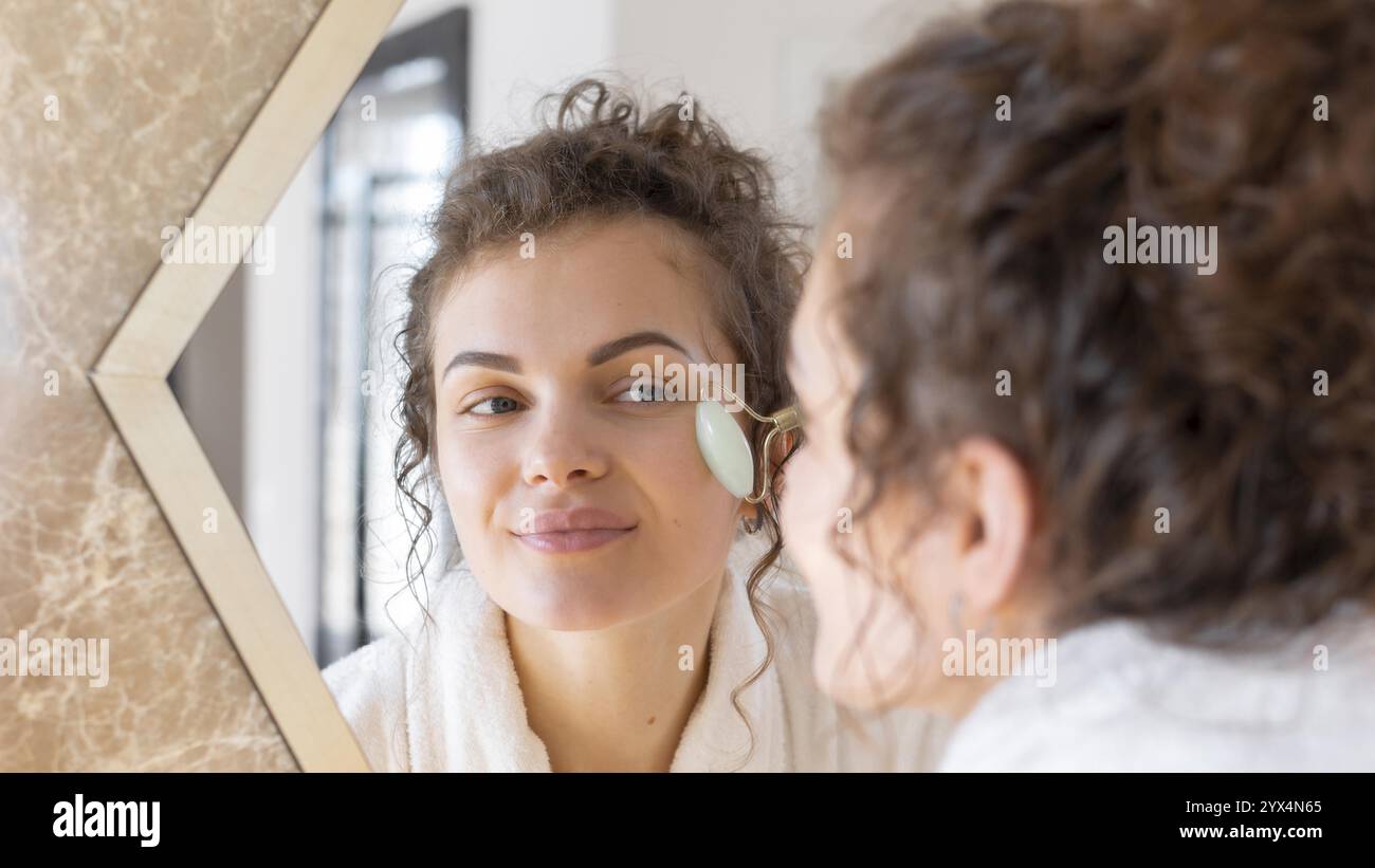 Femme regardant le miroir faisant le massage du visage 4 Banque D'Images