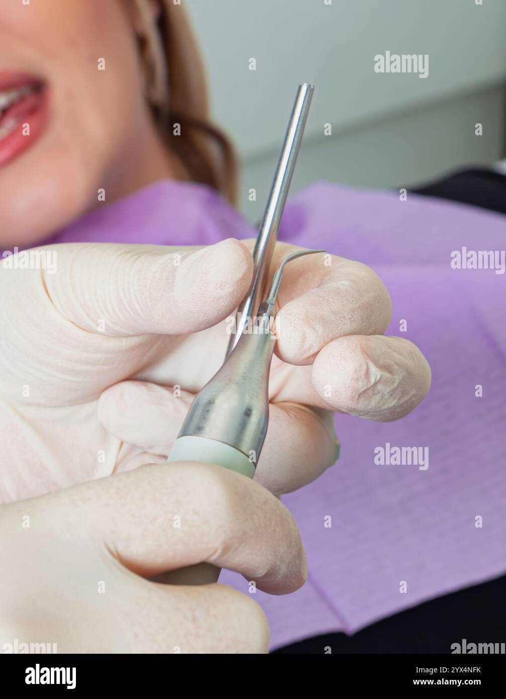 Dentiste portant des gants tenant l'équipement dentaire lors de la préparation d'un examen de patient dans une clinique dentaire Banque D'Images