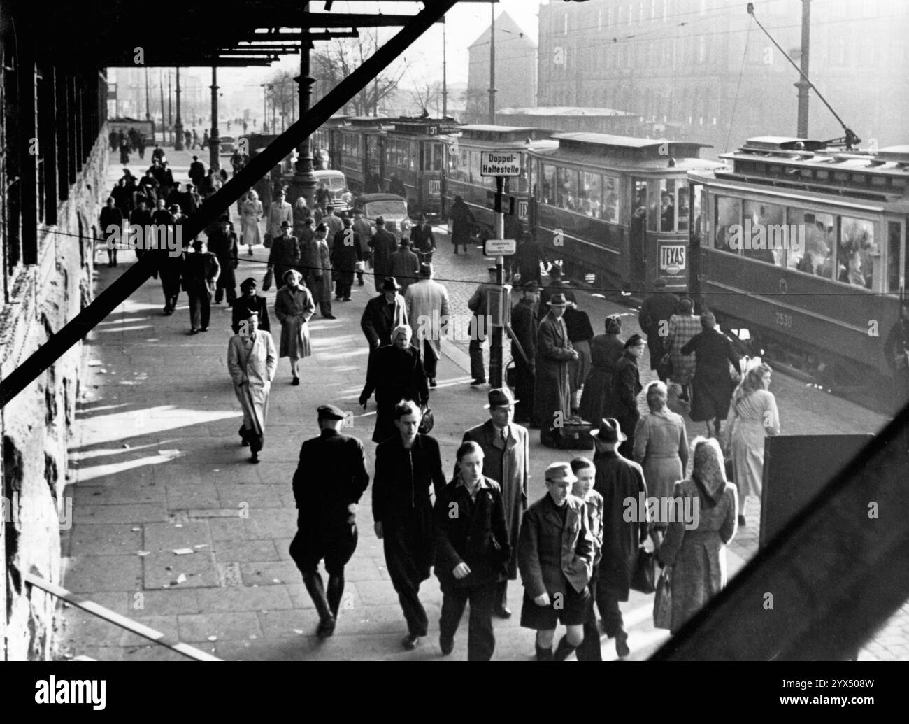 Les piétons longent les tramways à l'arrêt Steintordamm à Hambourg. [traduction automatique] Banque D'Images