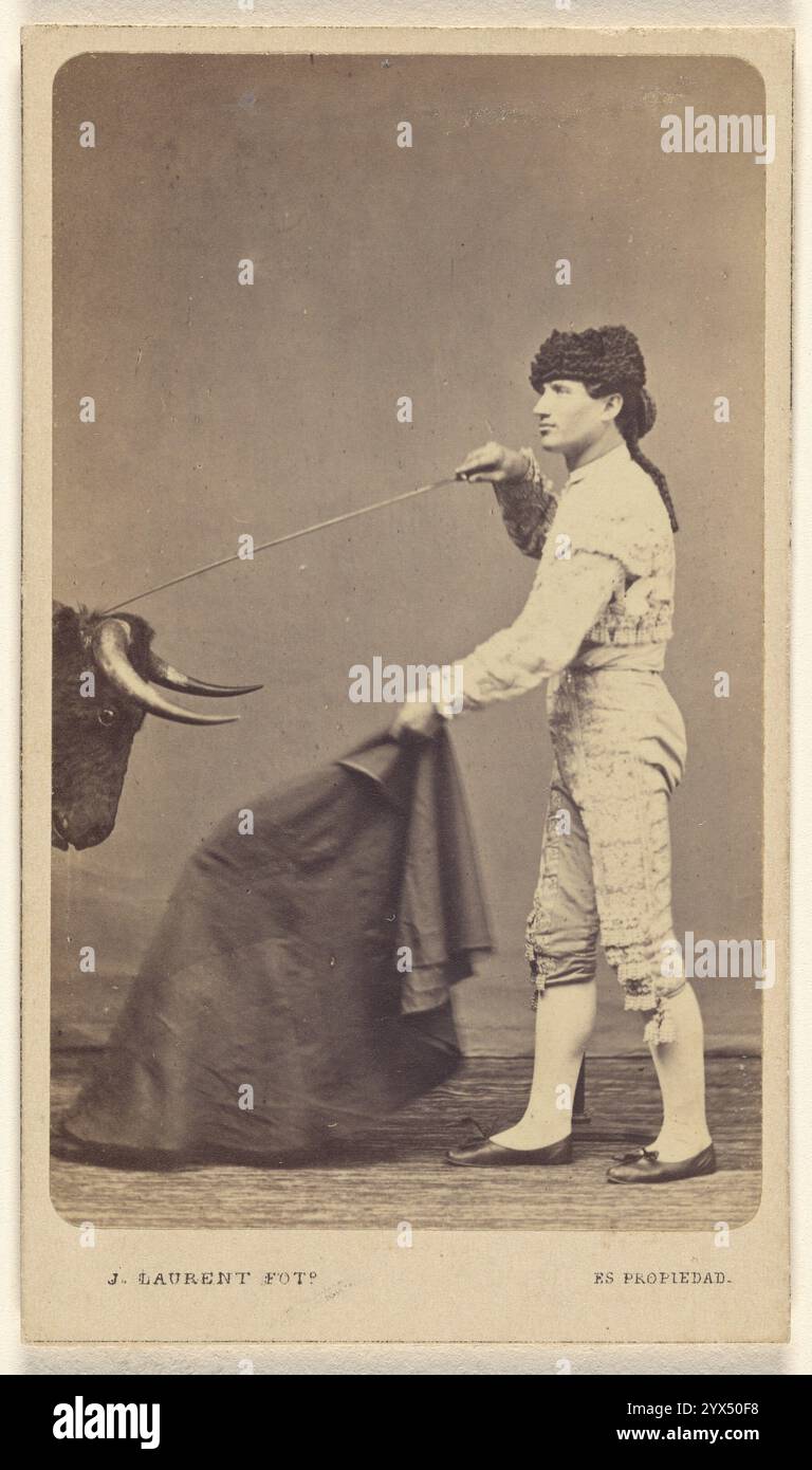 Torero en studio, vers 1865. Torero en studio poignardant un faux taureau dans la tête avec une épée, et tenant une cape. Banque D'Images