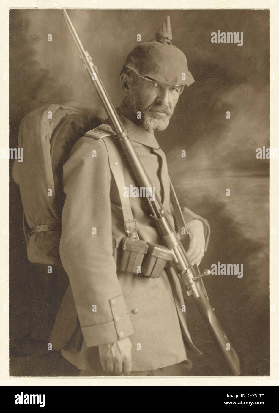 Soldat en uniforme WWI, 1914. Informations supplémentaires : un portrait en studio d'un soldat allemand portant un uniforme de la première Guerre mondiale avec des manchettes Brandenburg et un Pickelhaube. Il tient un fusil à baïonnette sur son épaule et a un sac à dos sur son dos. Banque D'Images