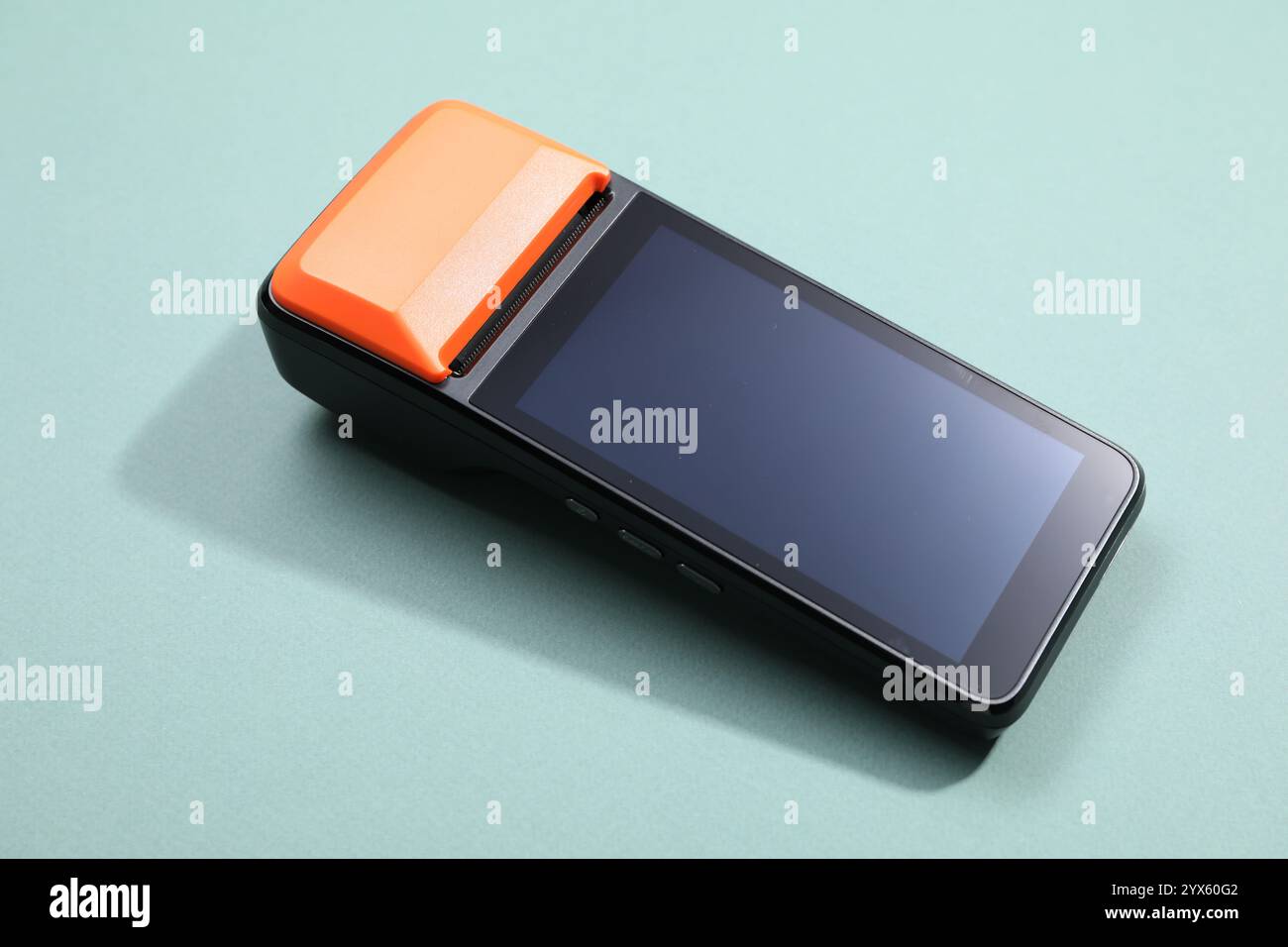 Un terminal de paiement sur fond turquoise pâle, gros plan Banque D'Images