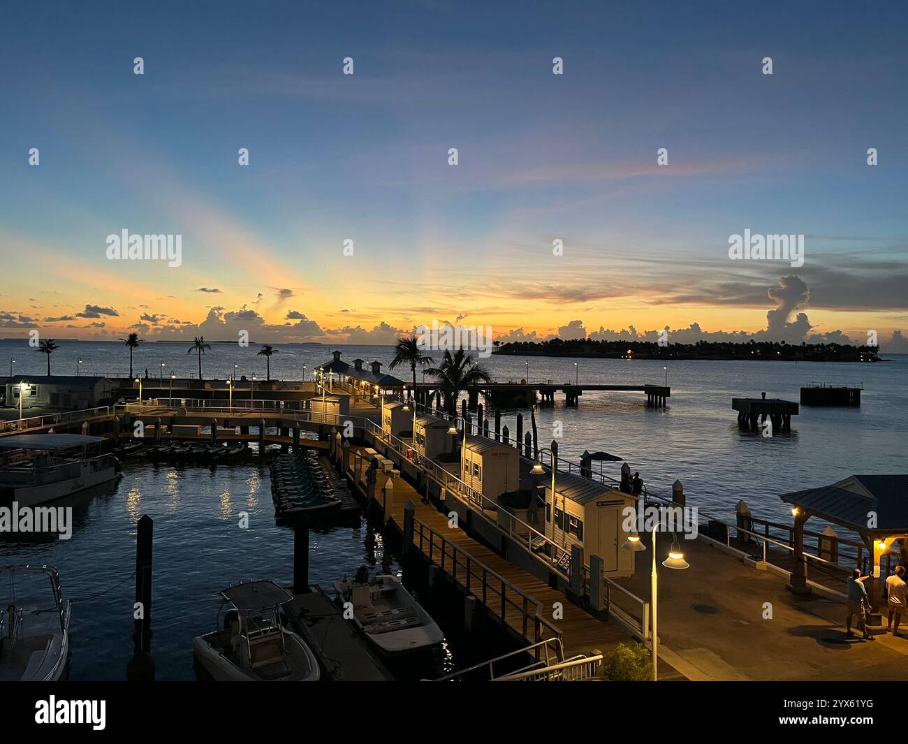 Superbe coucher de soleil sur la marina en bord de mer avec jetée et palmiers Banque D'Images