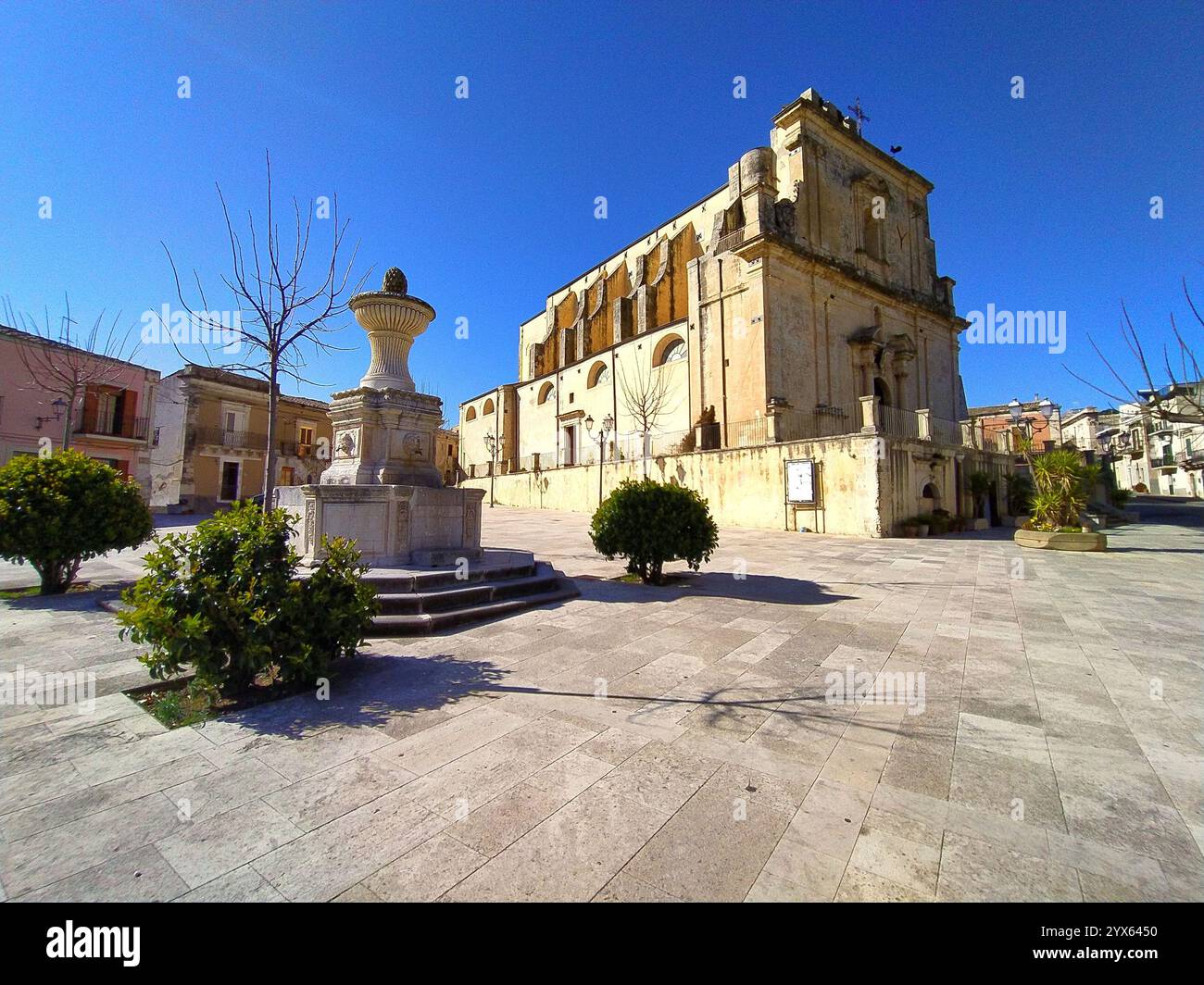 Fontaine en pierre monumentale dans la ville historique de Ferla, en Sicile, avec la Chiesa Madre en arrière-plan sous un ciel bleu, adaptée aux influenceurs et au contenu cr Banque D'Images