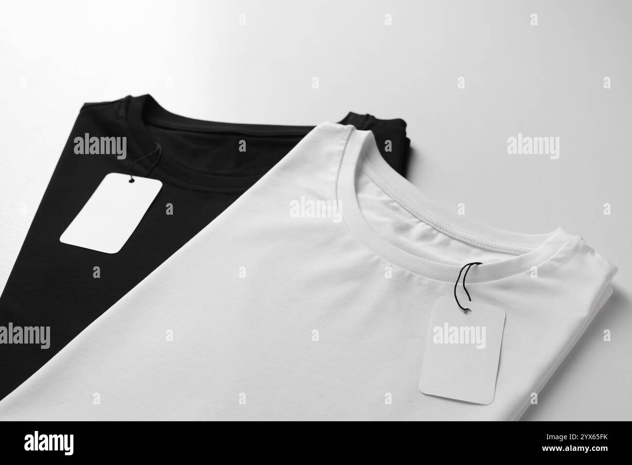 Différents t-shirts vierges sur fond blanc, gros plan. Maquette pour le design Banque D'Images Différents t-shirts vierges sur fond blanc, gros plan. Maquette pour le design Banque D'Images