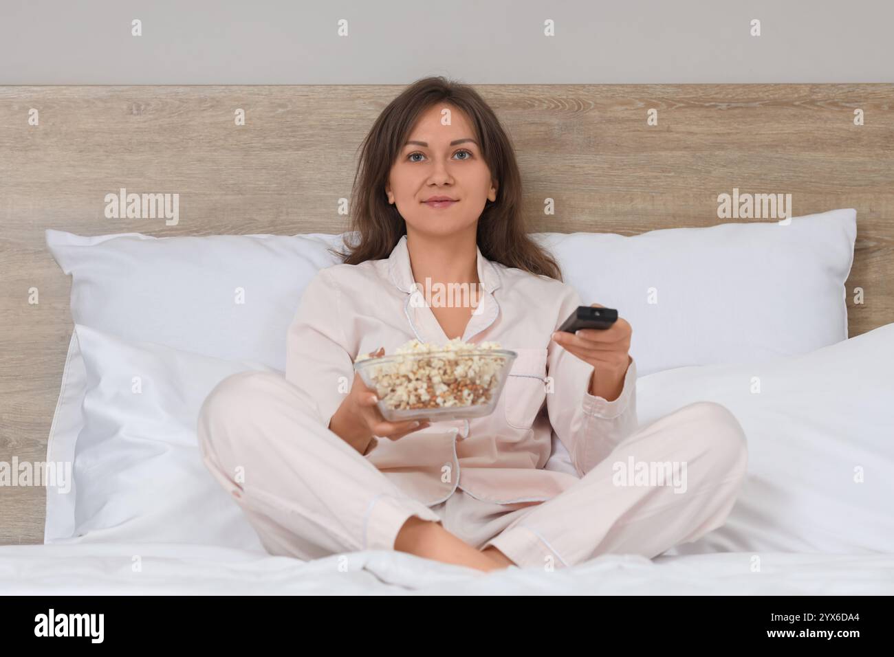 Jeune femme avec pop-corn regardant le film dans la chambre Banque D'Images