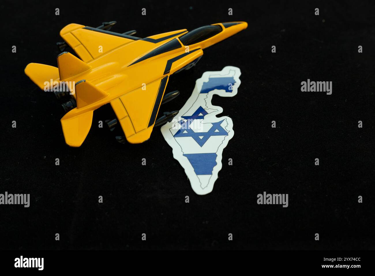 Un avion de chasse jouet avec la carte d'Israël sur fond noir Banque D'Images