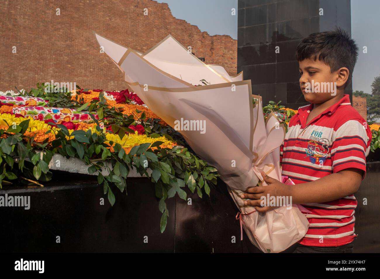 Dhaka, Bangladesh. 14 décembre 2024. Un garçon tient des fleurs pendant le mémorial intellectuel martyrisé. Le jour commémoratif des intellectuels martyrs, le Bangladesh commémore de nombreux intellectuels bengalis qui ont tragiquement perdu la vie pendant la guerre de libération du Bangladesh en 1971. Ces intellectuels ont été délibérément ciblés et brutalement tués dans l'ex-Pakistan oriental par l'armée pakistanaise et leurs alliés, pour saper la nation émergente en éradiquant ses individus talentueux et intellectuels. (Photo de Sazzad Hossain/SOPA images/SIPA USA) crédit : SIPA USA/Alamy Live News Banque D'Images