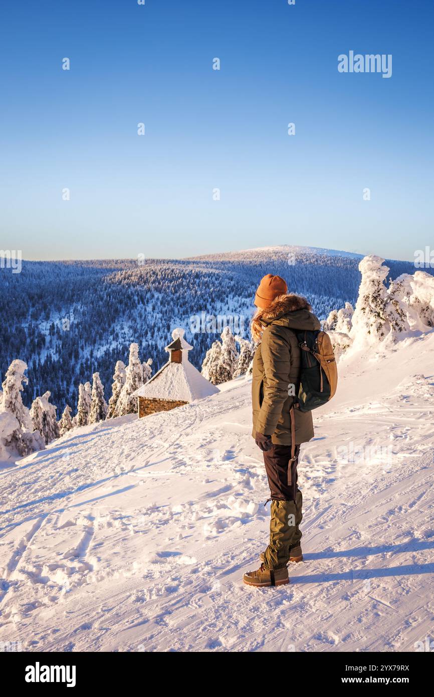 Femme randonnée dans les montagnes Jeseniky en hiver. Touriste féminine cherchant à de beaux paysages de neige du sommet connu sous le nom de Red Mountain Banque D'Images