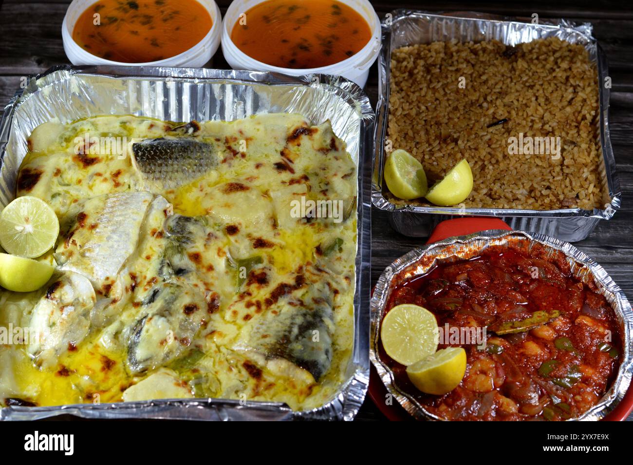 Repas de fruits de mer de poissons de mulet cuits au four avec sauce blanche crémeuse, morceaux de pommes de terre, riz de poisson rouge, crevettes cuites au four avec sauce rouge et fruits de mer c Banque D'Images