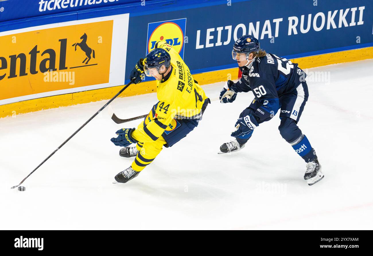 Fribourg, Suisse, 14 décembre 2024 : #44 Victor Ejdsell (Suède) couvre la rondelle contre #50 Juuso Riikola (Finlande). (Photo de Andreas Haas/dieBildmanufaktur) crédit : dieBildmanufaktur/Alamy Live News Banque D'Images