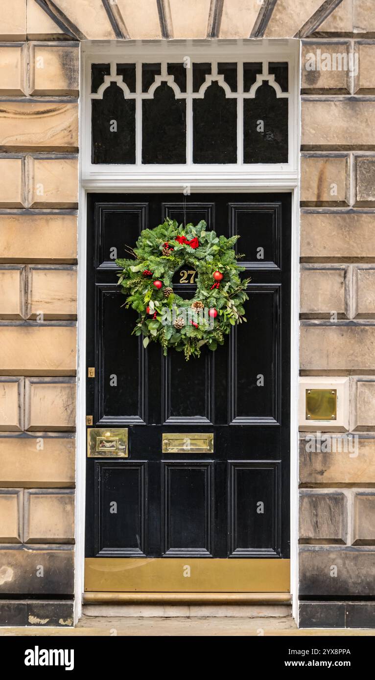 Panneau avant géorgien peint porte noire avec lumière de ventilateur et couronne de Noël, Edinburgh New Town, Écosse, Royaume-Uni Banque D'Images