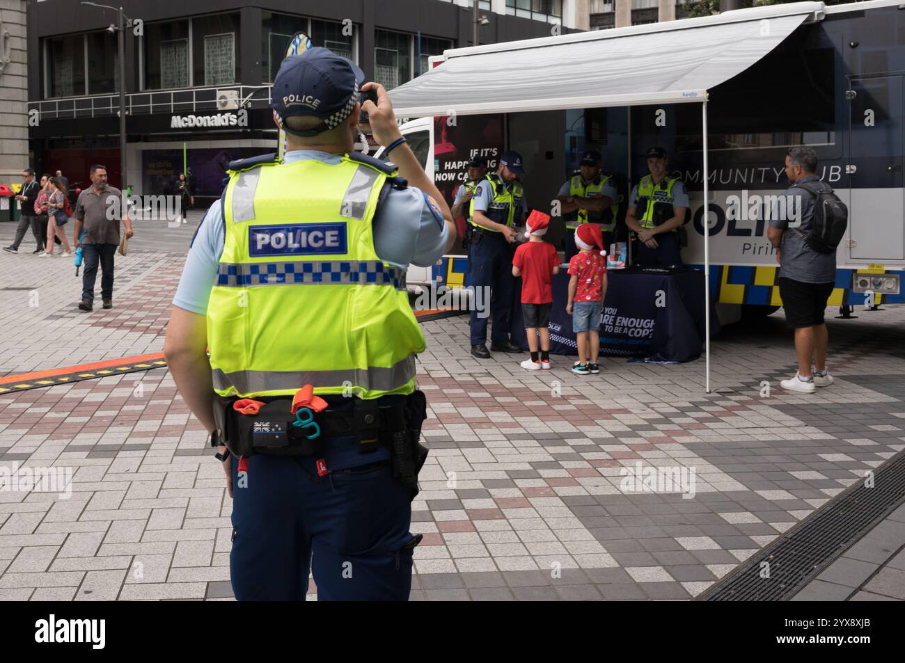 Police locale dans la communauté. Exercice de relations publiques distribuant des bonbons à Noël. Banque D'Images
