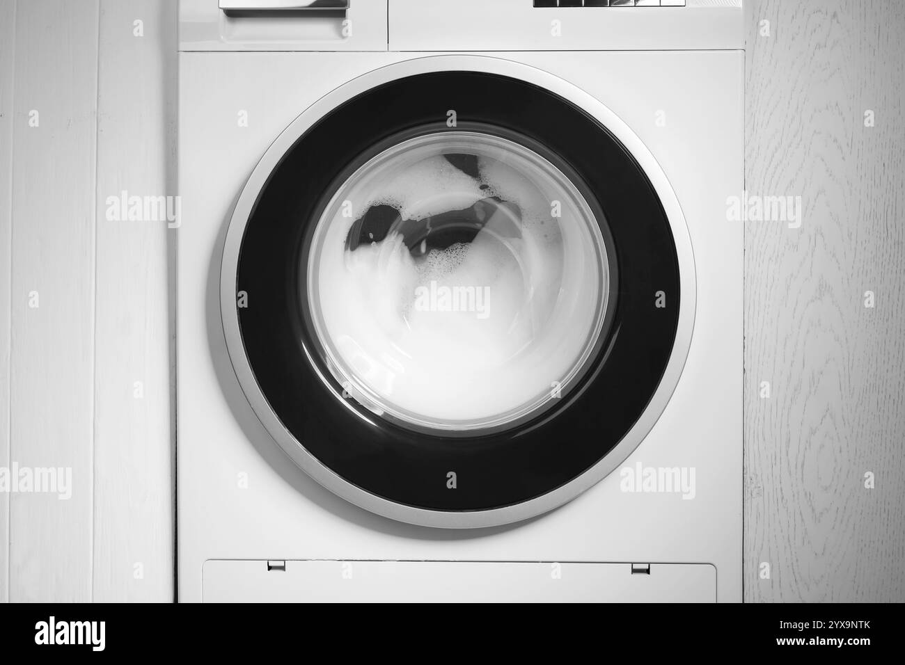 Machine à laver avec des mousses comme fond, gros plan Banque D'Images
