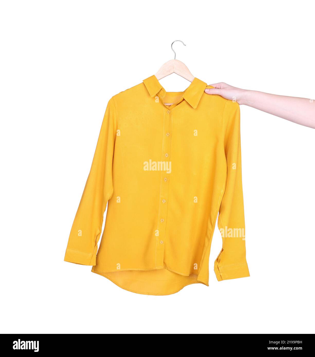 Femme tenant un cintre avec une chemise jaune sur fond blanc, gros plan Banque D'Images