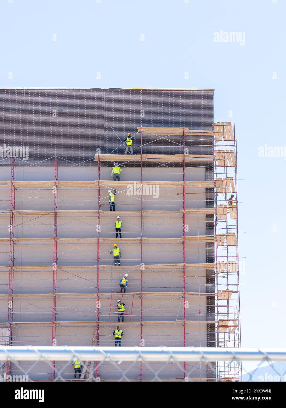 Travailleurs méconnaissables enlevant des planches de bois d'échafaudage sur un chantier de construction à Salt Lake City, Utah, États-Unis Banque D'Images