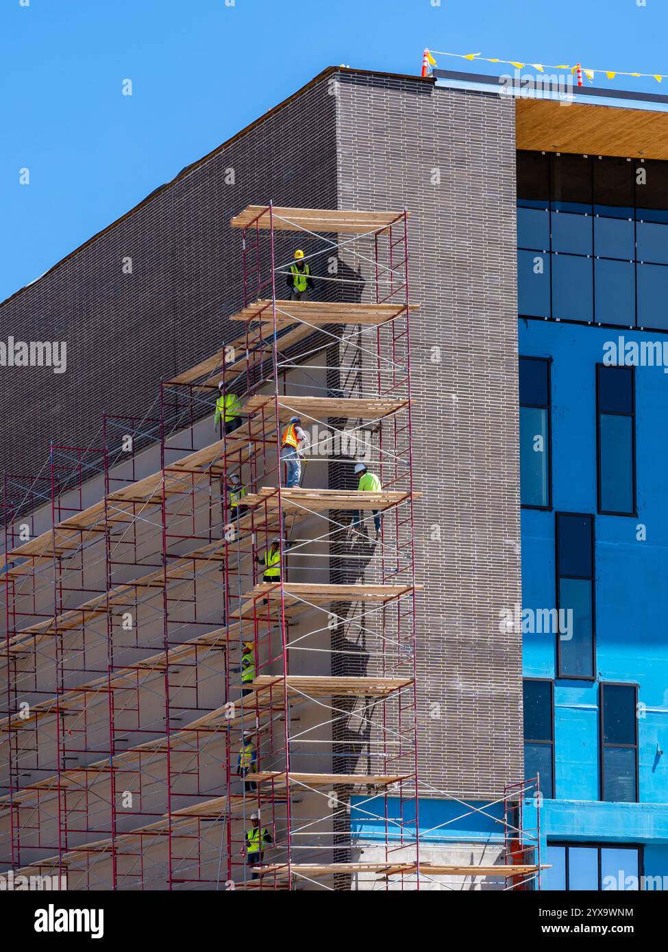 Travailleurs méconnaissables enlevant des planches de bois d'échafaudage sur un chantier de construction à Salt Lake City, Utah, États-Unis Banque D'Images