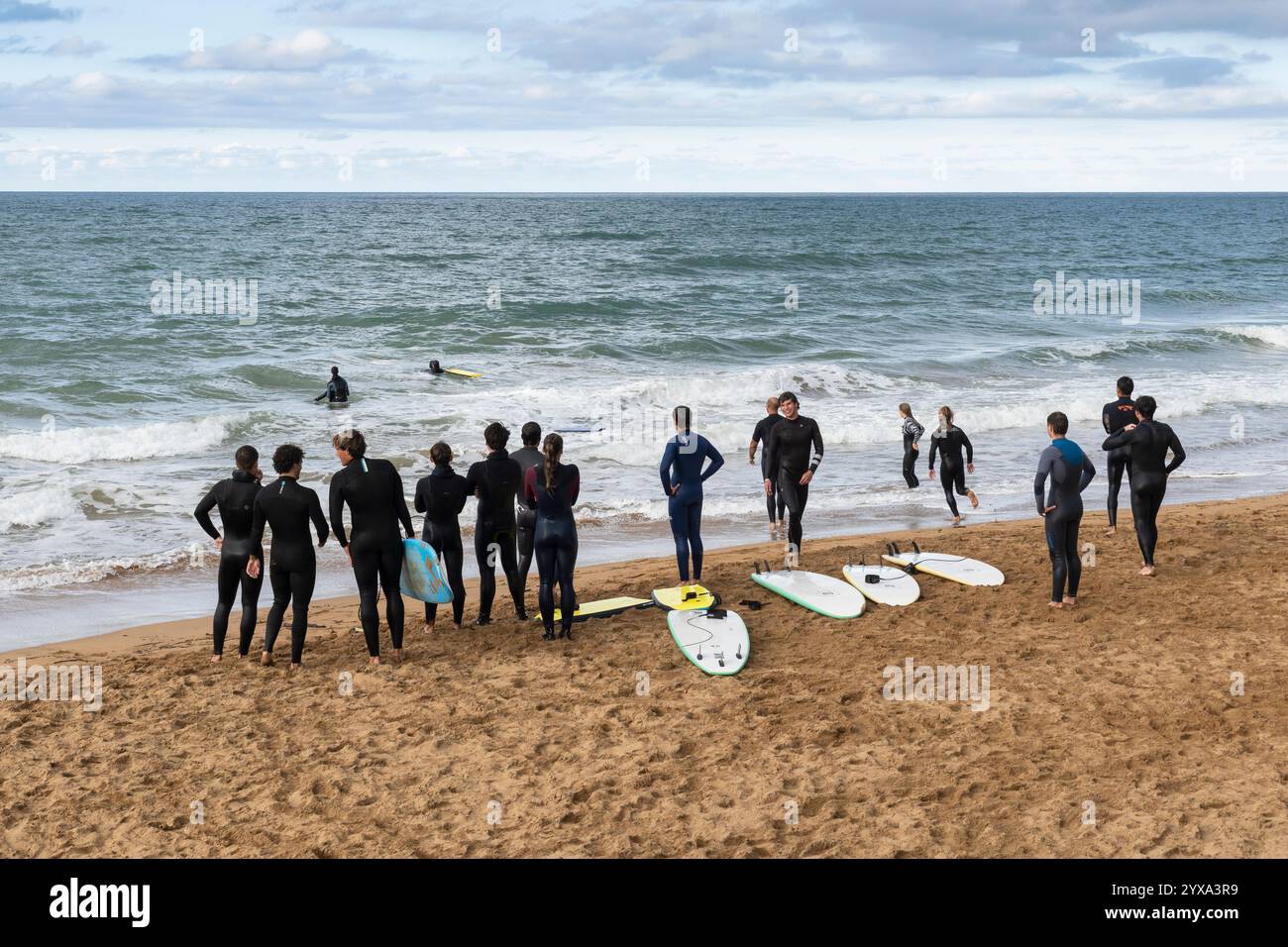 Un groupe de jeunes surfeurs se réunit à Playa de Zarautz à Zarautz, pays Basque, Espagne. Le village balnéaire populaire se trouve le long de la route Camino del Norte Banque D'Images