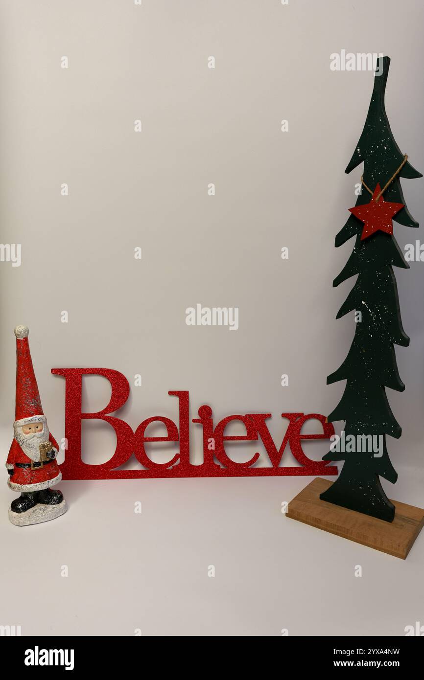 Le mot croire à côté d'un arbre de Noël sculpté avec un fond blanc propre sans couture Banque D'Images