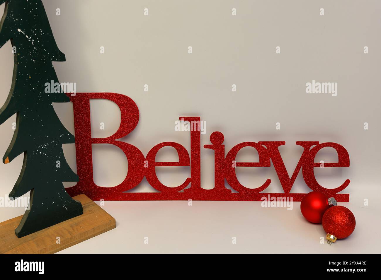 Le mot croire à côté d'un arbre de Noël sculpté avec un fond blanc propre sans couture Banque D'Images Le mot croire à côté d'un arbre de Noël sculpté avec un fond blanc propre sans couture Banque D'Images