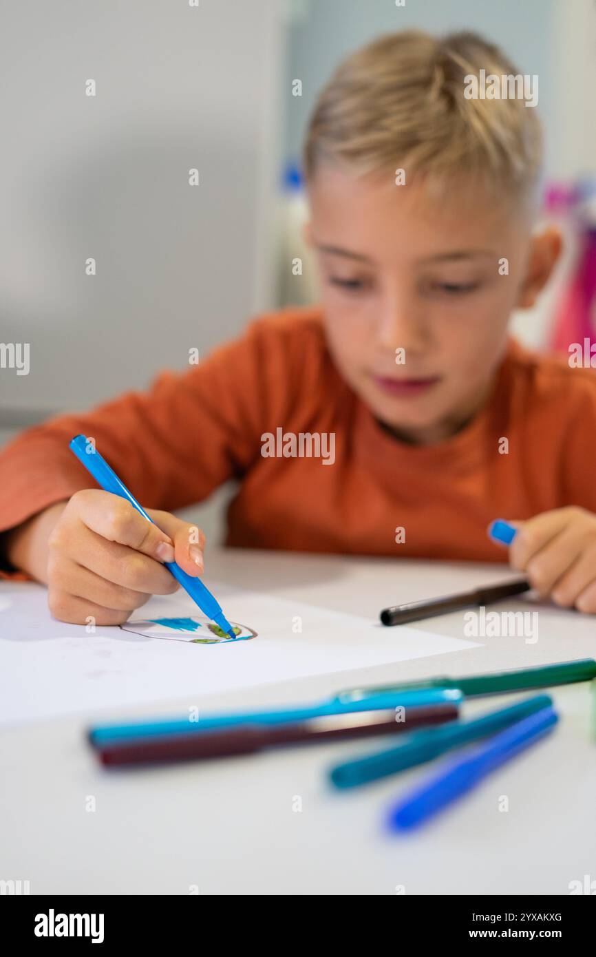 Enfant utilisant des marqueurs colorés pour dessiner, développant la créativité et la motricité fine Banque D'Images