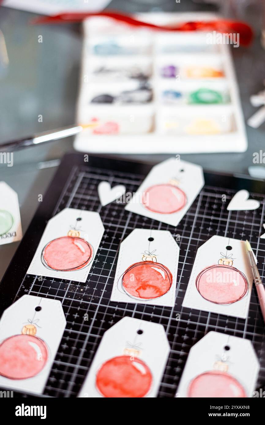 Vue de dessus des étiquettes cadeaux de Noël faites à la main avec boules de Noël peintes à l'aquarelle Banque D'Images