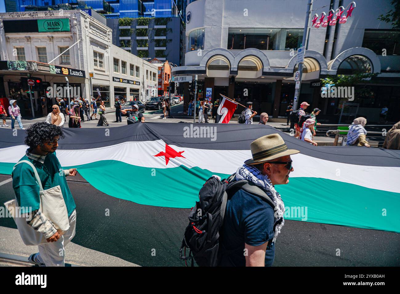 Melbourne, Australie. 15 décembre 2024. Les manifestants tiennent le drapeau de la Syrie pendant le rassemblement. Les manifestants brandissent des drapeaux palestiniens et brandissent des banderoles appelant à la fin du génocide et de l'agression sioniste, scandant en solidarité pour la libération et la justice palestiniennes. (Photo de Ye Myo Khant/SOPA images/Sipa USA) crédit : Sipa USA/Alamy Live News Banque D'Images