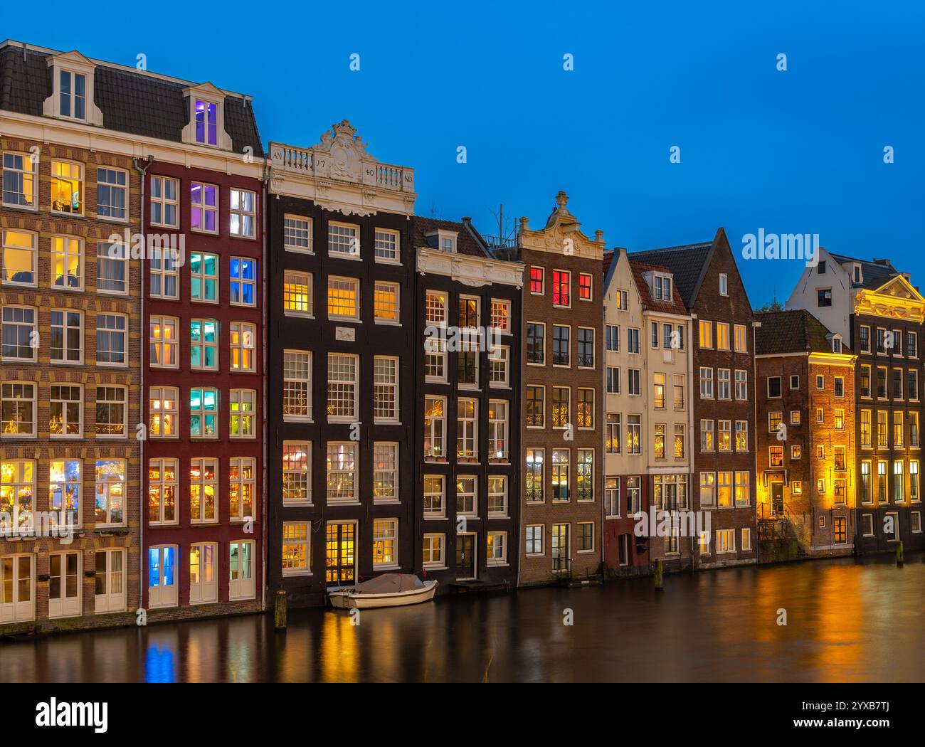 Architecture hollandaise typique, pittoresques maisons de canal à Amsterdam Damrak dans la soirée Banque D'Images