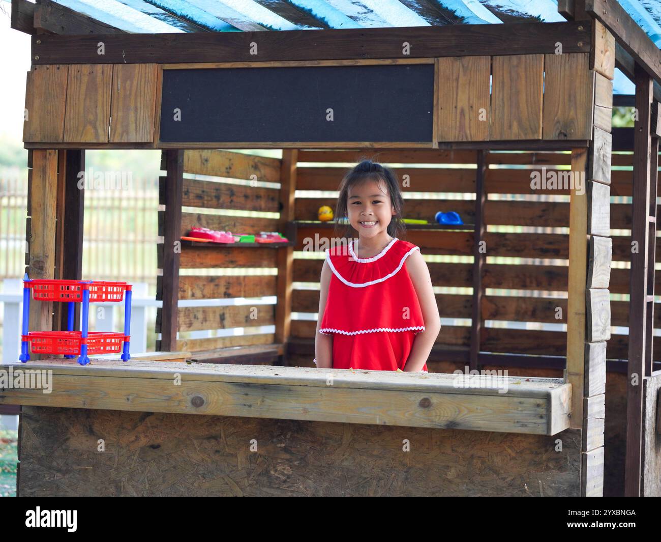 Fille mignonne jouant dans le terrain de jeu pendant les vacances d'été. Enfants heureux s'amusant dans un parc extérieur. Banque D'Images