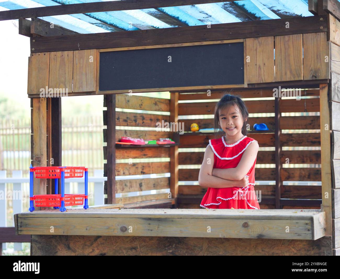 Fille mignonne jouant dans le terrain de jeu pendant les vacances d'été. Enfants heureux s'amusant dans un parc extérieur. Banque D'Images