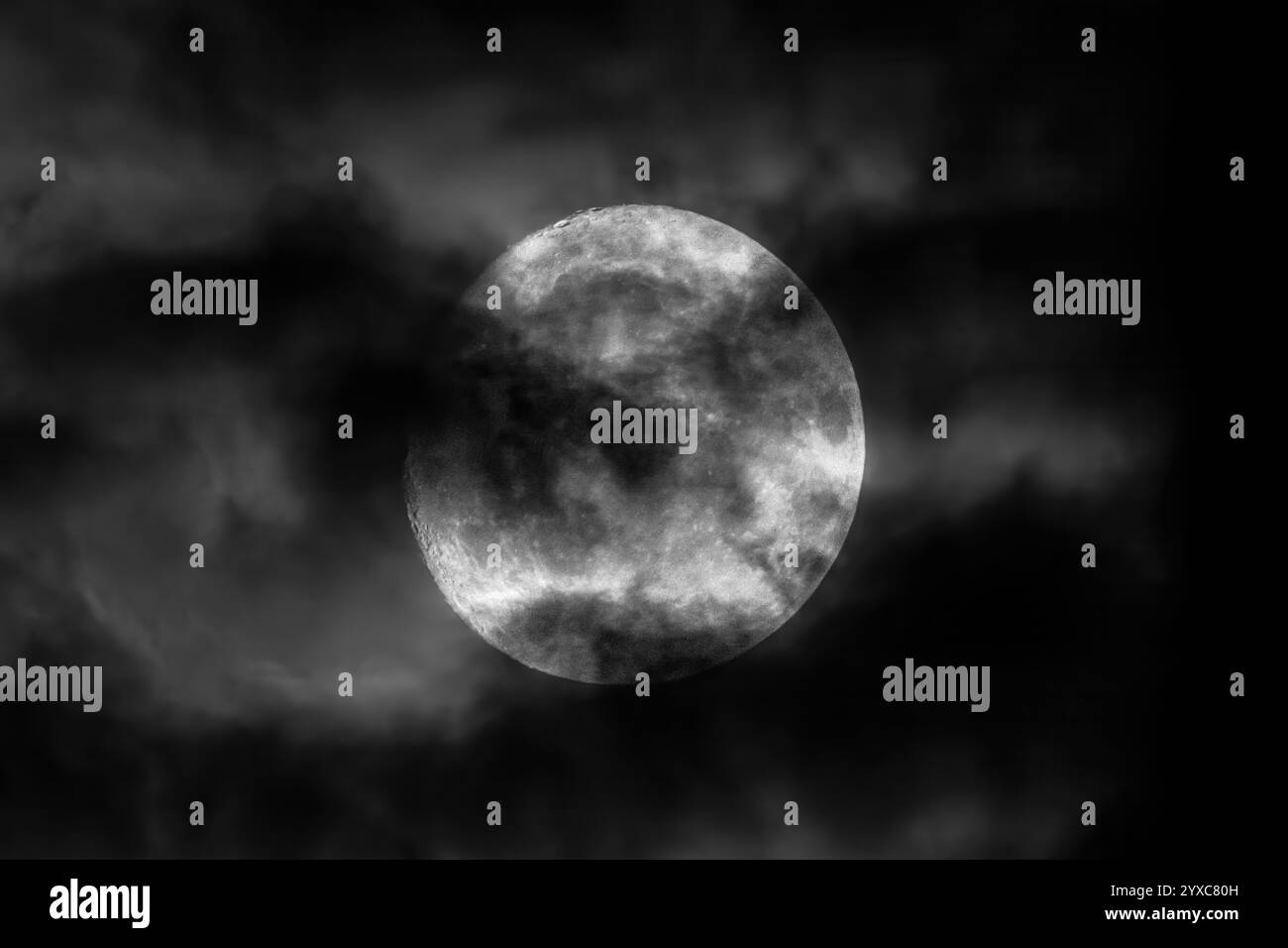 Une lune mystique brille parmi les nuages sombres, créant une scène enchanteresse rêveuse Banque D'Images