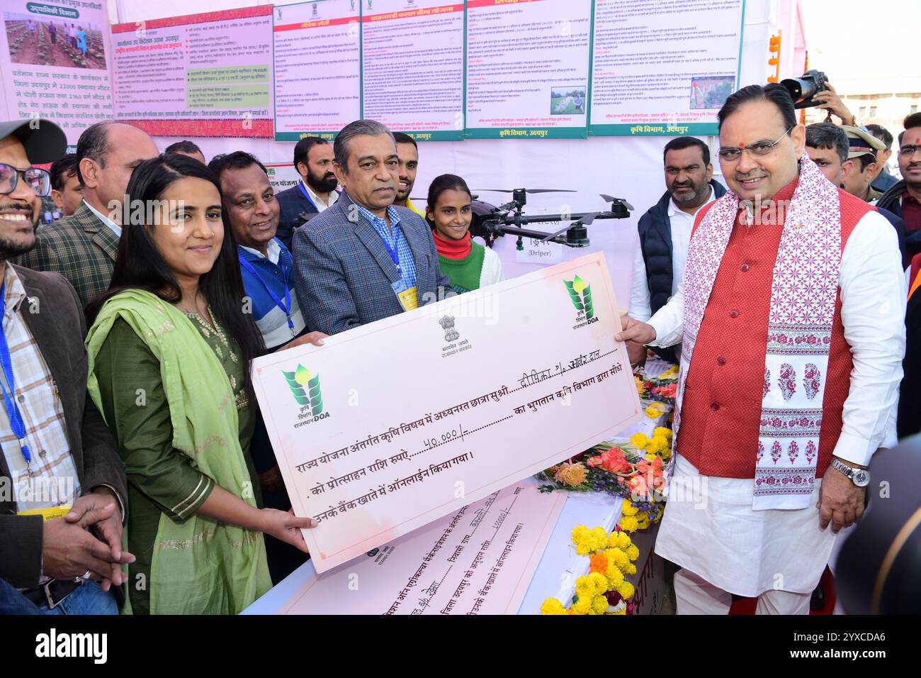 Udaipur, Inde, 14 décembre 2024 : le ministre en chef du Rajasthan, Bhajanlal Sharma, remet un chèque à une étudiante en agriculture lors de la conférence des femmes au niveau de l'État sur le premier anniversaire du gouvernement de l'État, au Gandhi Ground à Udaipur. Crédit : Sumit Saraswat / Alamy Live News Banque D'Images