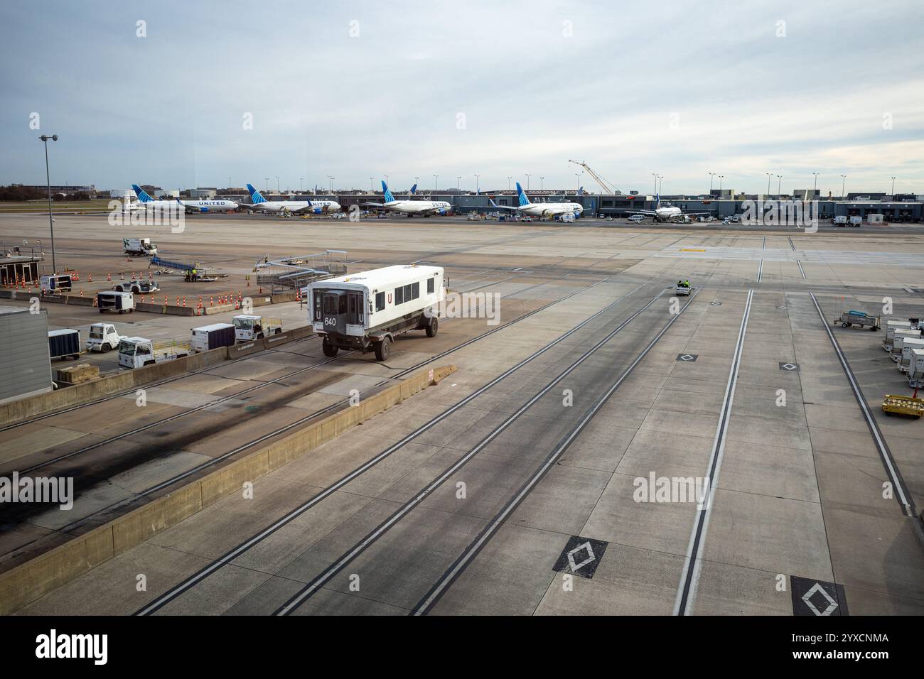 Une scène animée à l'aéroport de Dulles, Washington, avec des bus qui font la navette entre les terminaux, encadrés par la tour de contrôle et des avions immobilisés au sol. Banque D'Images