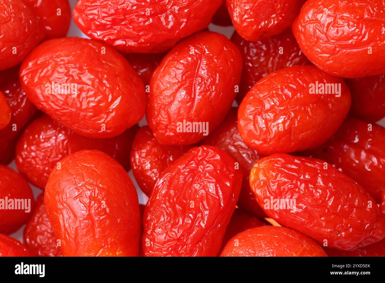 Tomates ridées : une métaphore naturelle du vieillissement cutané. Fond blanc. Photo macro d'une peau de tomate vieillissante Banque D'Images