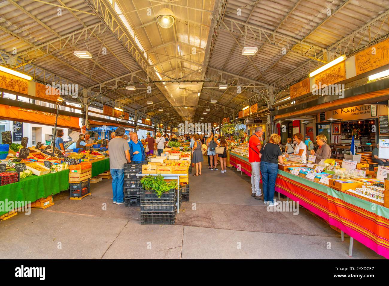 Les habitants et les touristes achètent le marché provençal couvert proposant des fruits et des produits frais dans la ville méditerranéenne d'Antibes, en France. Banque D'Images